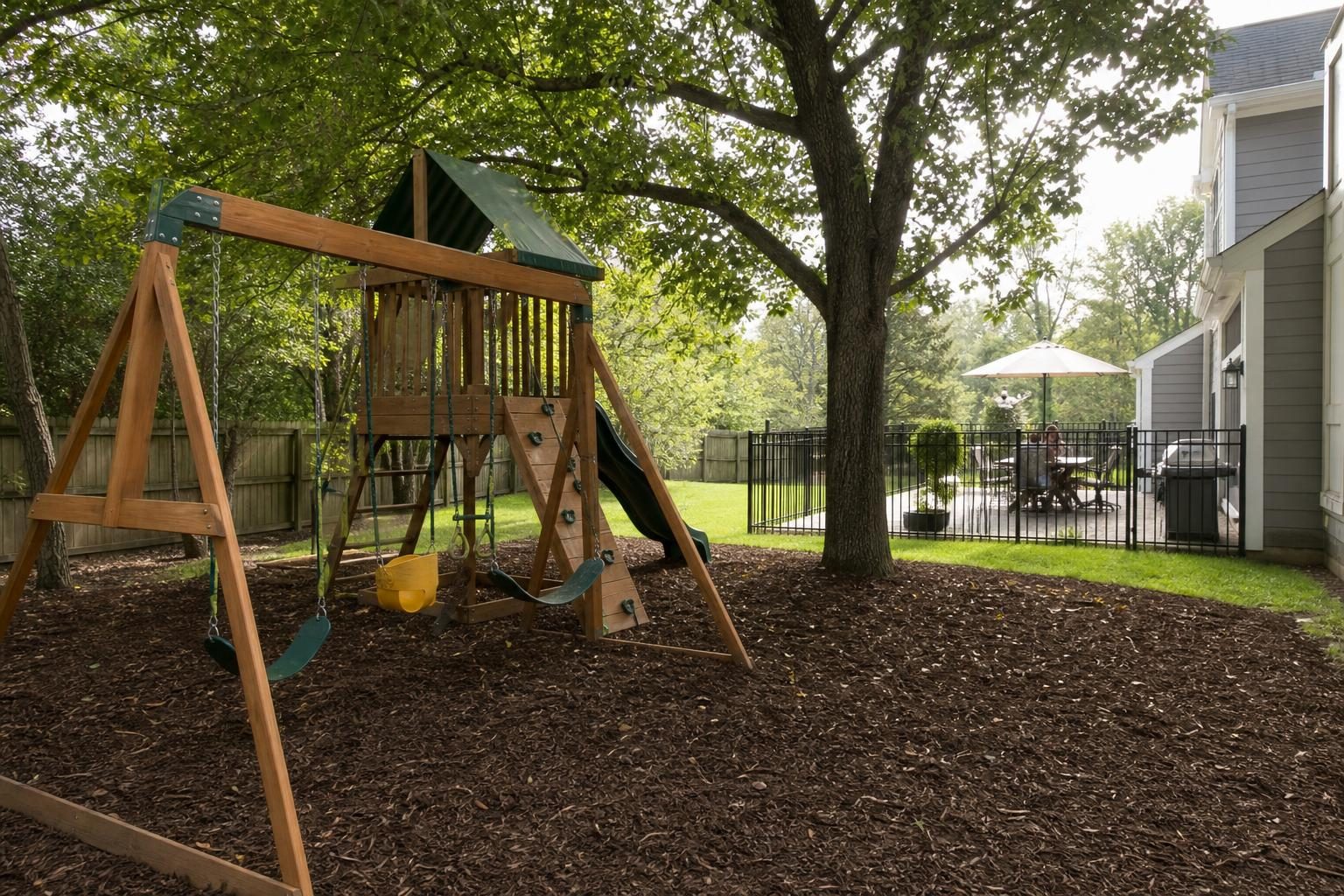 A play area on deep safety mulch, shaded and visible from the house, avoids common kid-friendly yard mistakes.